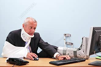 Injured businessman working at his desk