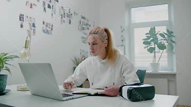 Pretty young freelance programmer surfs internet in office