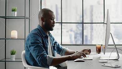 Afro-american financial analyst types report on computer