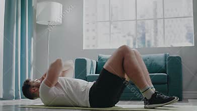 Professional athlete guy with beard practices crunches