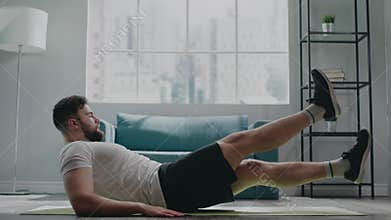 Muscular athlete with beard practices flutter kicks exercise