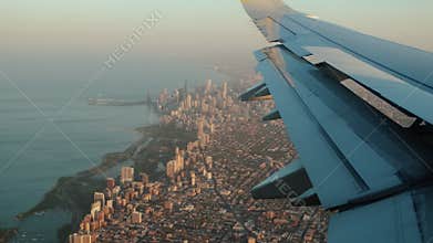Flying into Chicago. flight with detail of plane with suburbs of Chicago below.