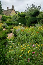The picturesque garden at Hidcote Manor in the English Cotswolds, designed by Lawrence Johnston. Box hedge in foreground.