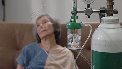 Elderly woman wearing oxygen nasal canula at home
