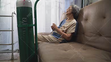 Elderly woman wearing oxygen nasal canula at home