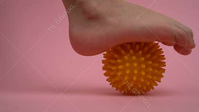prevention of children's flat feet and valgus of the foot, exercises with massage balls on a pink background