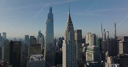 forwards ascending fly above buildings in town. Heading to iconic Chrysler buildings with crown and spire. Manhattan