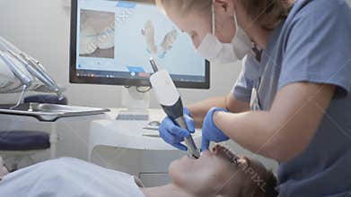 Orthodontist using 3D intraoral scanner for scanning teeth patient's. Modern dental clinic with equipment. Dentistry and