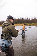 Man reeling in fish in alaska