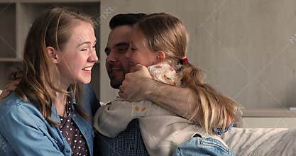 Happy excited young mother preteen daughter embrace kiss beloved father