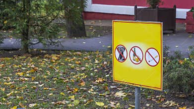 Three prohibiting red signs on a yellow background. No dog, no smoking, no drinks signs.
