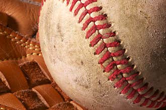 Close up of an old baseball in a mitt.