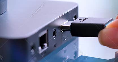 Hand holding HDMI cable to connect to device.