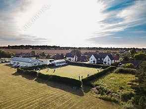 Sutton Suffolk UK June 15 2021: Aerial view on a village bowling green with people playing lawn bowls on a summers evening