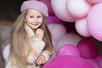Happy smiling, laughing little girl in beret playing with pink, purple balloons, outdoors. childrens emotions.