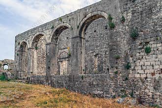 Ancient stone wall with arched holes in Rozafa Castle in Albania