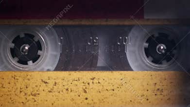 Vintage Yellow Audio Cassette Playing in Deck of an Old Tape Recorder