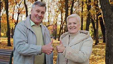 Portrait of happy elderly caucasian family wife husband senior grandparents stand outdoor in autumn park smiling old
