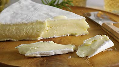 Pieces of fresh French brie cheese on a cutting board