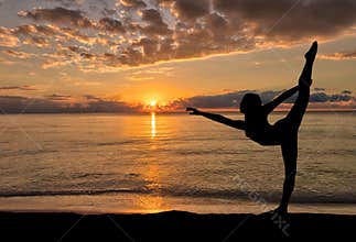 Silhouette of girl enjoying her morning dance exercise at a beach sunrise