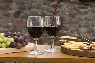 Cheese, grapes, bread, wine on a table