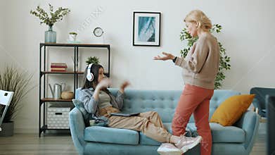 Teenage girl listening to music and using laptop then fighting with mother at home