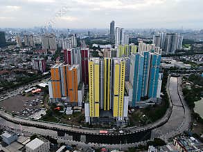 Aerial drone view of modern apartment building in Jakarta central business district with Jakarta cityscape and noise cloud.