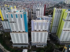 Aerial drone view of modern apartment building in Jakarta central business district with Jakarta cityscape and noise cloud.