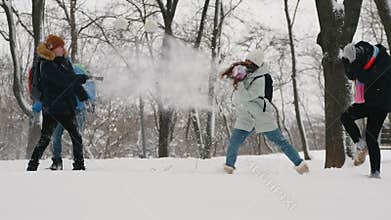 Teens ave fun throwing snow at each other in city park