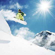 Snowboarder at jump inhigh mountains