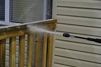 Cleaning House Deck in summer with pressure hose