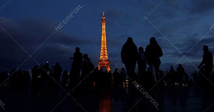 People and tourists walk on the Palais de Chaillot esplanade after sunset to photograph the Eifell tower.