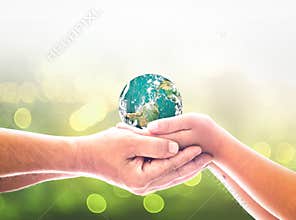 Adult and Child Hands Gently Holding Planet Earth Together against Soft Green Bokeh Background