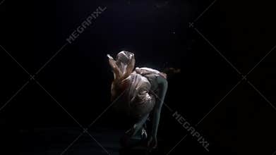 breathless woman is floating underwater, female corpse is drowning in dark depth