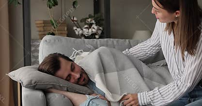 Loving wife cover sleeping beloved man with warm plaid