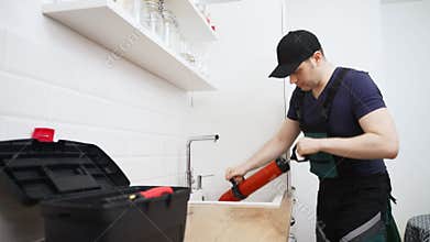 Plumber unclogging kitchen sink