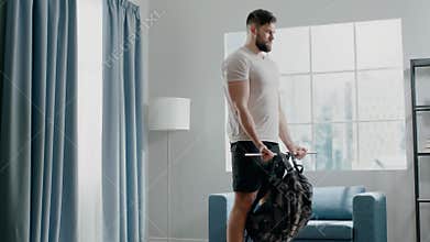 Sportsman exercises biceps curl with weight in bag on stick