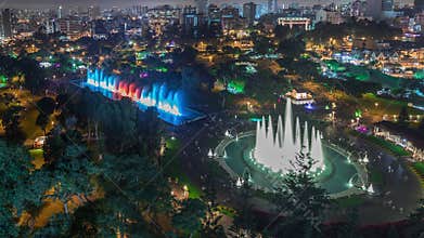 Aerial view to Park of the Reserve with colorful magic water circuit biggest fountain complex night timelapse