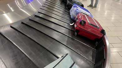 Various suitcases moving on the luggage conveyor belt at arrival area in the passenger terminal at larnaca International