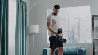 Serious athlete exercises biceps curl with heavy dumbbells