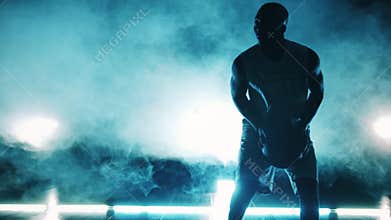 Dark hall with a sportsman having a basketball practice. Professional sportsman, motivation, determination, healthy