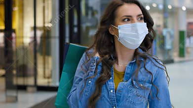 Video of young woman in shopping mall during pandemic.