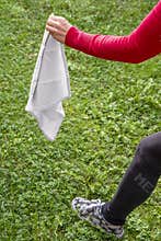 A woman is ready for a game of stealing the flag, with a white handkerchief in her hand