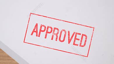 Close up hand putting stamp approved on paper concept bureaucracy