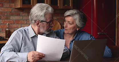 Happy middle aged family couple reading paper document.