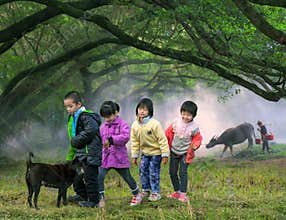 Children crossing farm field, China countryside