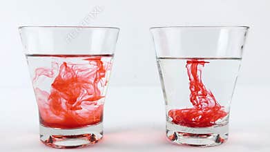 Pour red food coloring into a glass of warm water on the left and vinegar on the right, Diffusion science concept
