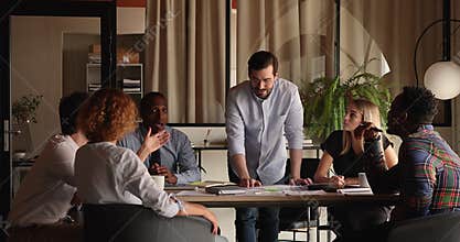 Multiracial teammates brainstorming during morning briefing in modern office boardroom