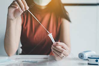 Patient woman using a covid-19 self test rapid antigen testing kit at home