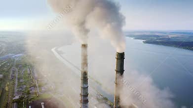 Aerial view of coal power plant high pipes with black smokestack polluting atmosphere. Electricity production with